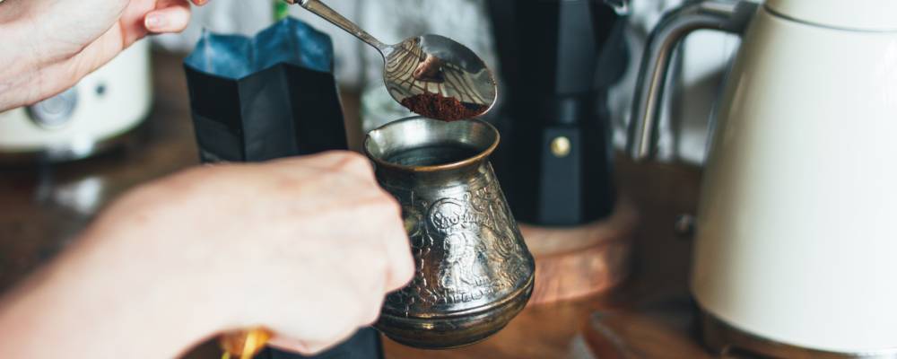 cezvede türk kahvesi yapan bir insan görseli
